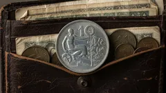 Staré československé mince a bankovky v kožené peněžence, detailní záběr.